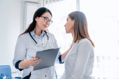 Doktor, hastanede çalışan bir kadınla konuşuyor.