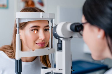 Modern klinikteki muayene sırasında kadın hastayla göz doktoru.