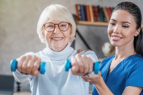 Alte Frau Trainiert Mit Physiotherapeutin Hause Mit Kurzhanteln — Stockfoto