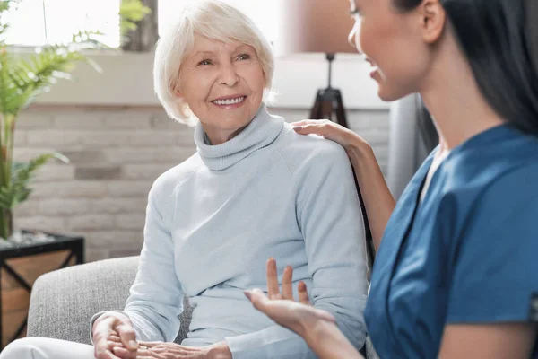 Cuidador Sorrindo Conversando Com Mulher Idosa Enquanto Cuida Dela Casa — Fotografia de Stock