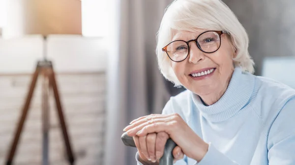 Portrait Happy Mature Woman Eyeglasses Holding Cane While Sitting Sofa — Stock Photo, Image
