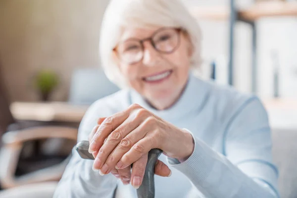 Idősebb Aki Sétapálcát Tart Miközben Otthon Kanapén Kezeire Koncentrál Idősek — Stock Fotó