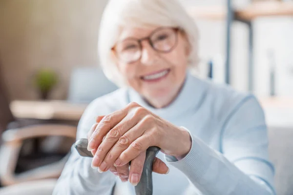 Senior Woman Holding Cane While Sitting Sofa Home Focus Hands — Stock Photo, Image