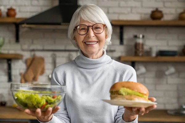 Gesundes Essen Ältere Lächelnde Frau Hält Salat Und Burger Der — Stockfoto