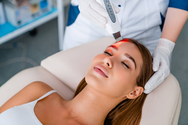 Cosmetologist make face while procedure ultrasound facial peeling in cosmetology cabinet