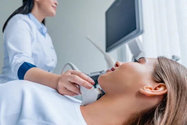 Doktor klinikte kadının ultrason muayenesi yapıyor.