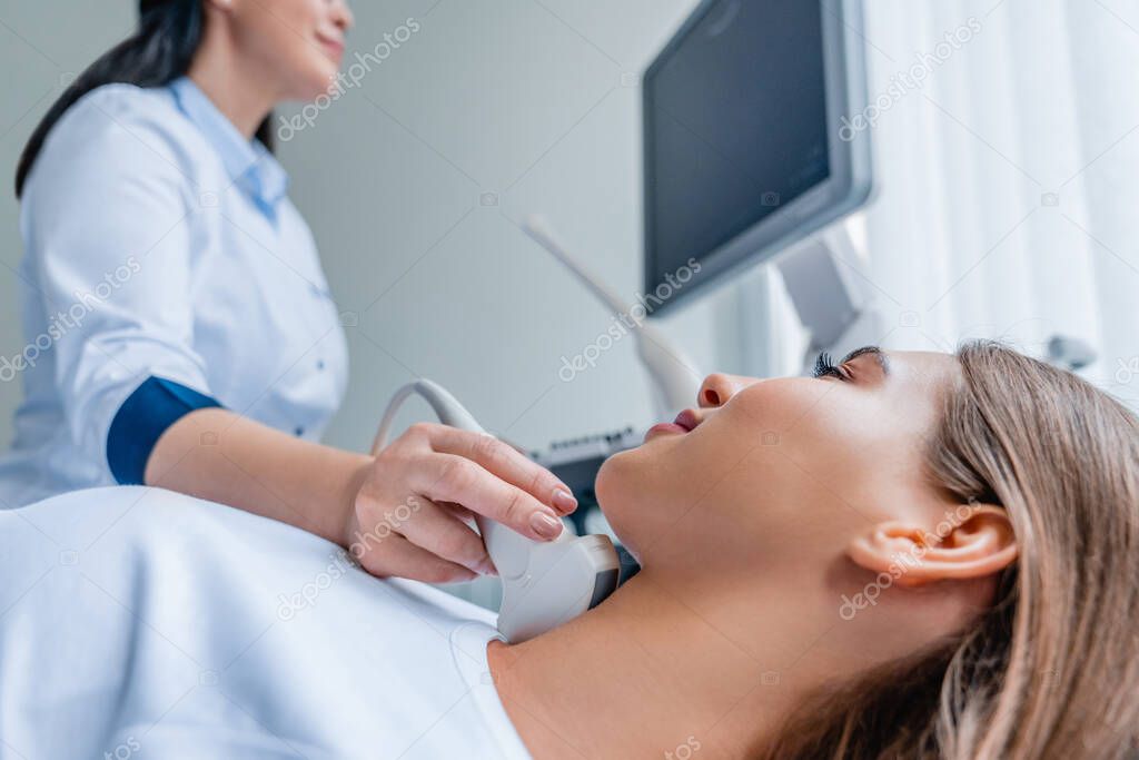 Doctor conducting ultrasound examination of woman in clinic