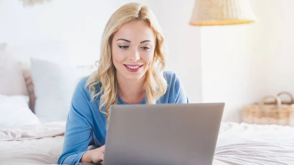 Potret Wanita Tersenyum Berbaring Tempat Tidur Dan Menggunakan Laptop Nya — Stok Foto