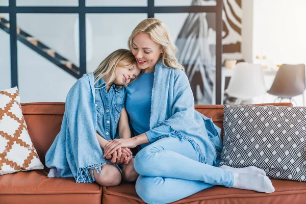 快乐的妈妈和她的小女儿抱在沙发上的毛毯下 — 图库照片