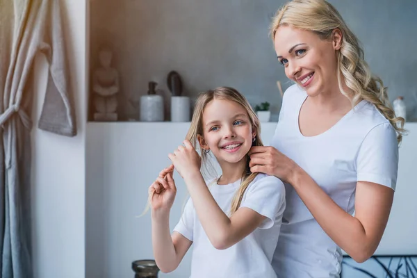 Smailing Mulher Fazendo Cabelo Sua Filha Casa — Fotografia de Stock