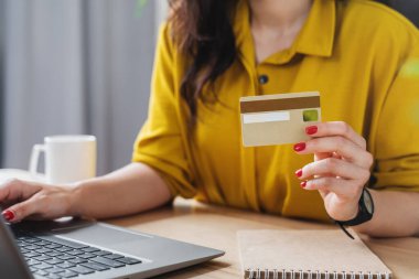 Kadının yakın oturduğu masada dizüstü bilgisayarla kredi kartı ödemesi yapılır.
