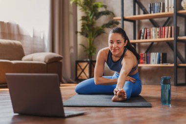 Evde kısırlaştırma yaparken yoga yapan bir sürü genç bayan.
