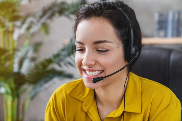 Portrait of cheerful girl operator manager talking on hot help line providing support service information at home office