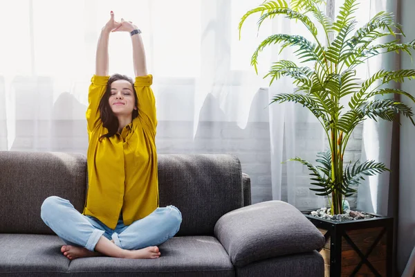 Tersenyum Puas Wanita Muda Peregangan Sambil Duduk Sofa — Stok Foto