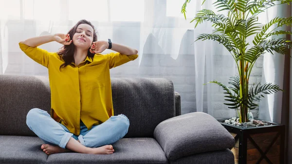 Wanita Muda Yang Ceria Meregang Sambil Duduk Sofa Semakin Santai — Stok Foto