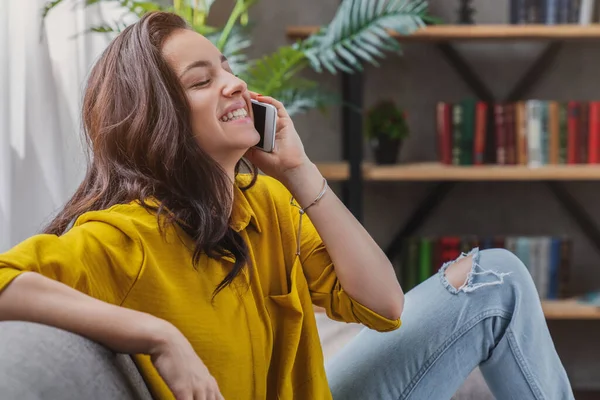 Wanita Muda Ceria Duduk Sofa Dan Berbicara Telepon Genggam Rumah — Stok Foto