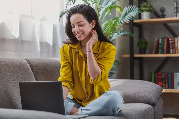 Wanita Muda Tersenyum Duduk Sofa Dan Menggunakan Laptop Untuk Bekerja — Stok Foto