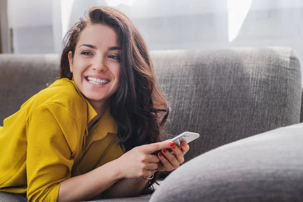 Junge Frau Lächelt Und Benutzt Handy Während Sie Mit Blick — Stockfoto