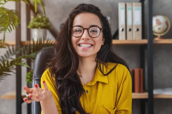 Genç bayan çalışanın videodaki görüntülerini, iş arkadaşlarıyla görüşmelerini, evdeki dizüstü bilgisayardan müşterilerine danışmalarını.