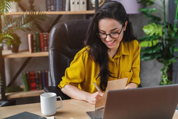 Jovem Mulher Sorridente Freelancer Sentado Escrevendo Planejador Dentro Casa Conceito — Fotografia de Stock