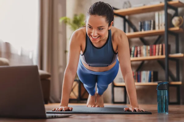 집에서 운동을 하면서 노트북으로 훈련하는 비디오를 여성을 가르치는 스톡 사진