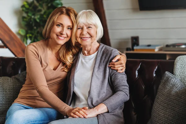 高齢の母親と中年の娘の肖像画一緒に笑顔上のザカウチに自宅 — ストック写真