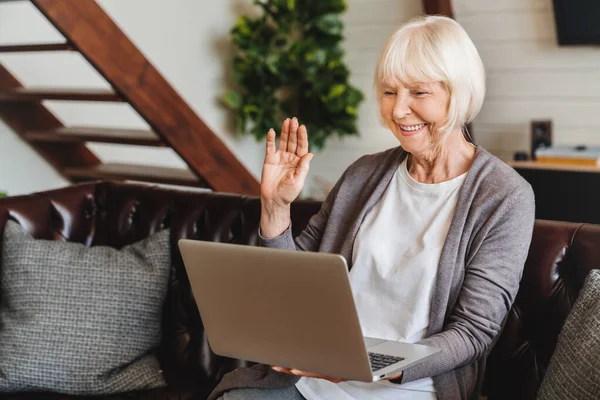 Leende Seniorkaukasiska Kvinna Sitter Soffan Våg Prata Videosamtal Bärbar Dator — Stockfoto