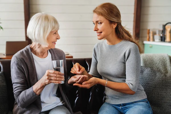 Senior Vrouw Het Nemen Van Pillen Van Haar Dochter Terwijl — Stockfoto