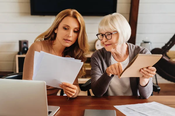 Blanke Vrouw Legt Een Aantal Documenten Facturen Uit Aan Ouder — Stockfoto