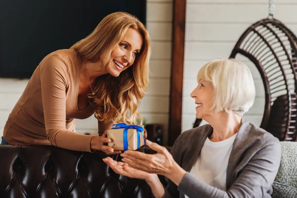 Medelålders Kvinnligt Barn Gör Närvarande Hälsning Hennes Glada Senior Mor — Stockfoto