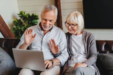Eski mutlu aile çiftimiz dizüstü bilgisayara bakıp uzaktan görüntülü konuşma yapıyor, online iletişim kuruyor.