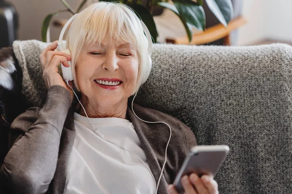 Feliz Anciana Madura Usar Auriculares Celebración Teléfono Inteligente Relajarse Con — Foto de Stock