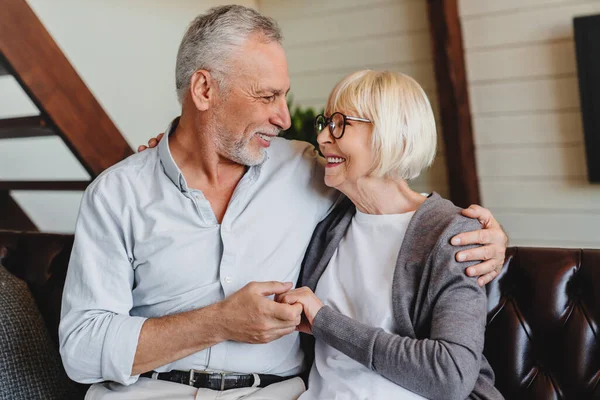 Romántica Pareja Ancianos Sentados Juntos Sofá Casa Sonriendo Felizmente —  Fotos de Stock