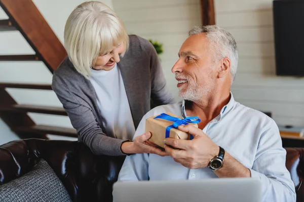 Senior Vrouw Feliciteert Haar Man Met Cadeau Voor Verjaardag Terwijl — Stockfoto