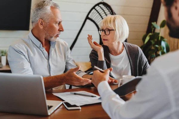 Financieel Adviseur Geeft Pensioenadvies Aan Oud Echtpaar Terwijl Thuis Ruzie — Stockfoto