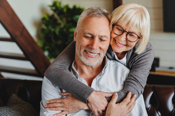 Beautiful Senior Couple Embracing Each Other While Sitting Couch Home Royalty Free Stock Images