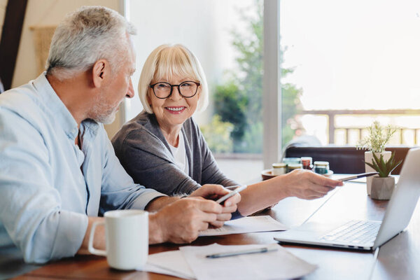 Senior Couple Doing Home Finances Using Laptop Indoors Stock Image