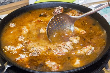 Paella et ve sebze tavada gıda süzme için kaşık ile pirinçli