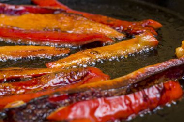 kırmızı biber dilimleri tavada yağı ile kızartma, yakın çekim 