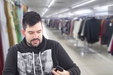 hareket eden telefon tutarak ve alışveriş dükkanında oturmuş sakallı 