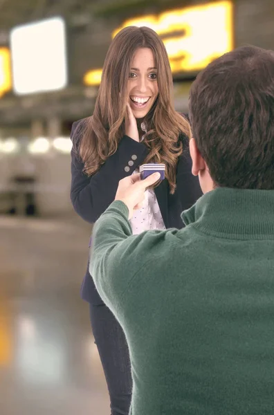 バレンタインの日 ギフト ボックスを与えると空港ターミナルに立っている男に幸せな女 — ストック写真