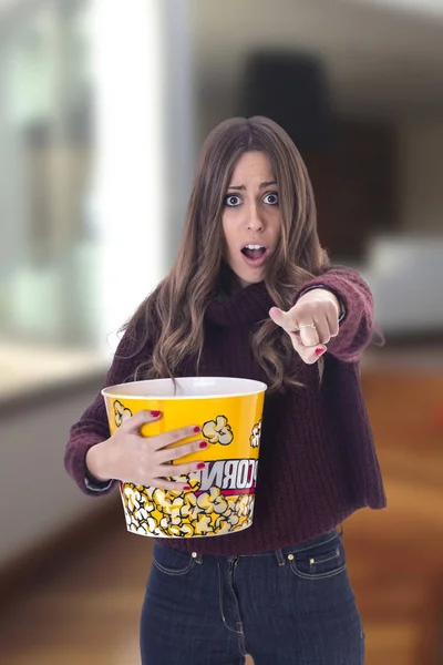 Verrast Jonge Vrouw Wijzend Camera Met Popcorn Mandje Handen — Stockfoto