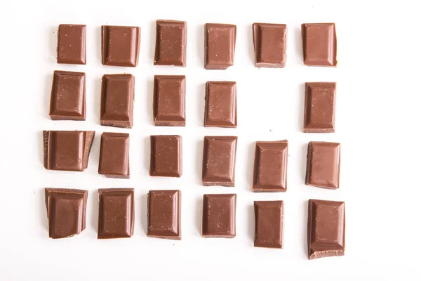 cracked brown chocolate pieces isolated on white, full frame image