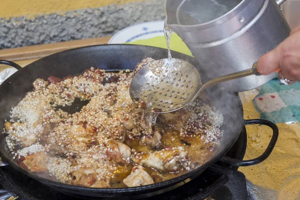Vaření Rýže Paella Kuřecím Masem Pánvi Pomocí Lžíce Pro Cezení — Stock fotografie