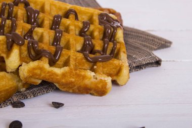 Belçika Waffle kahverengi peçete üzerinde çikolata şurubu ile