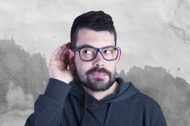 Gözlük takan ve elini kulağına tutarak sağır adam portresi 