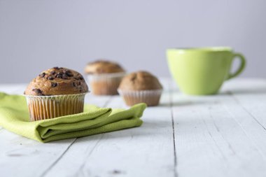 çikolata parçaları ile dekore edilmiş ev yapımı kek yemek masada Kupası ve yeşil peçete 