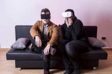 iki oyun erkeklerde Vr gözlük ve kanepe üzerinde oturan hayran 