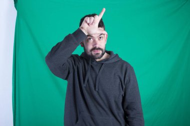 Kapüşonlu ve yeşil arka planı poz ve el, daha gevşek ile baş, el hareketi adam 