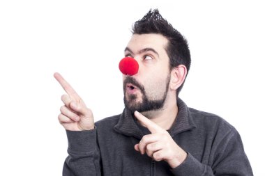 studio poz ve sol tarafta parmakları işaret palyaço burunlu komik adam 